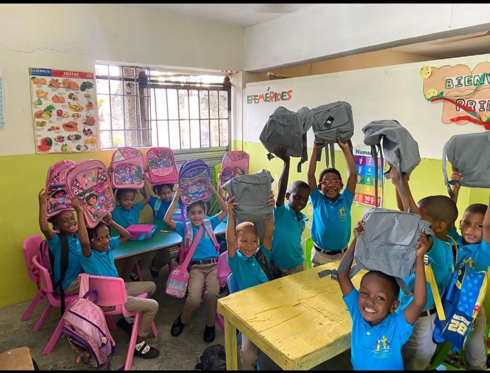 Niños de FUNACORE mostrando sus mochilas nuevas