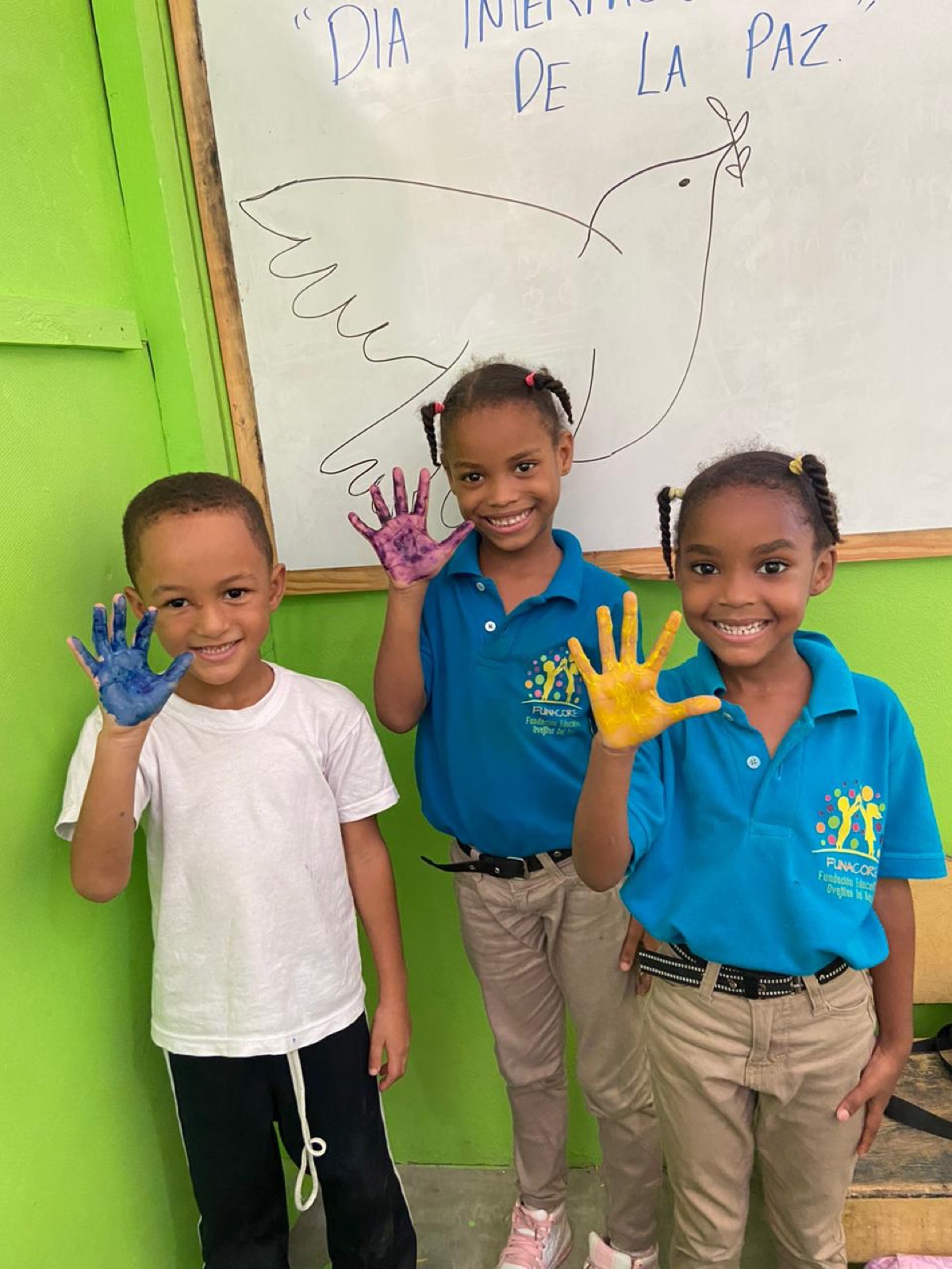 Niños de FUNACORE con las manos pintadas celebrando el Día de la Paz